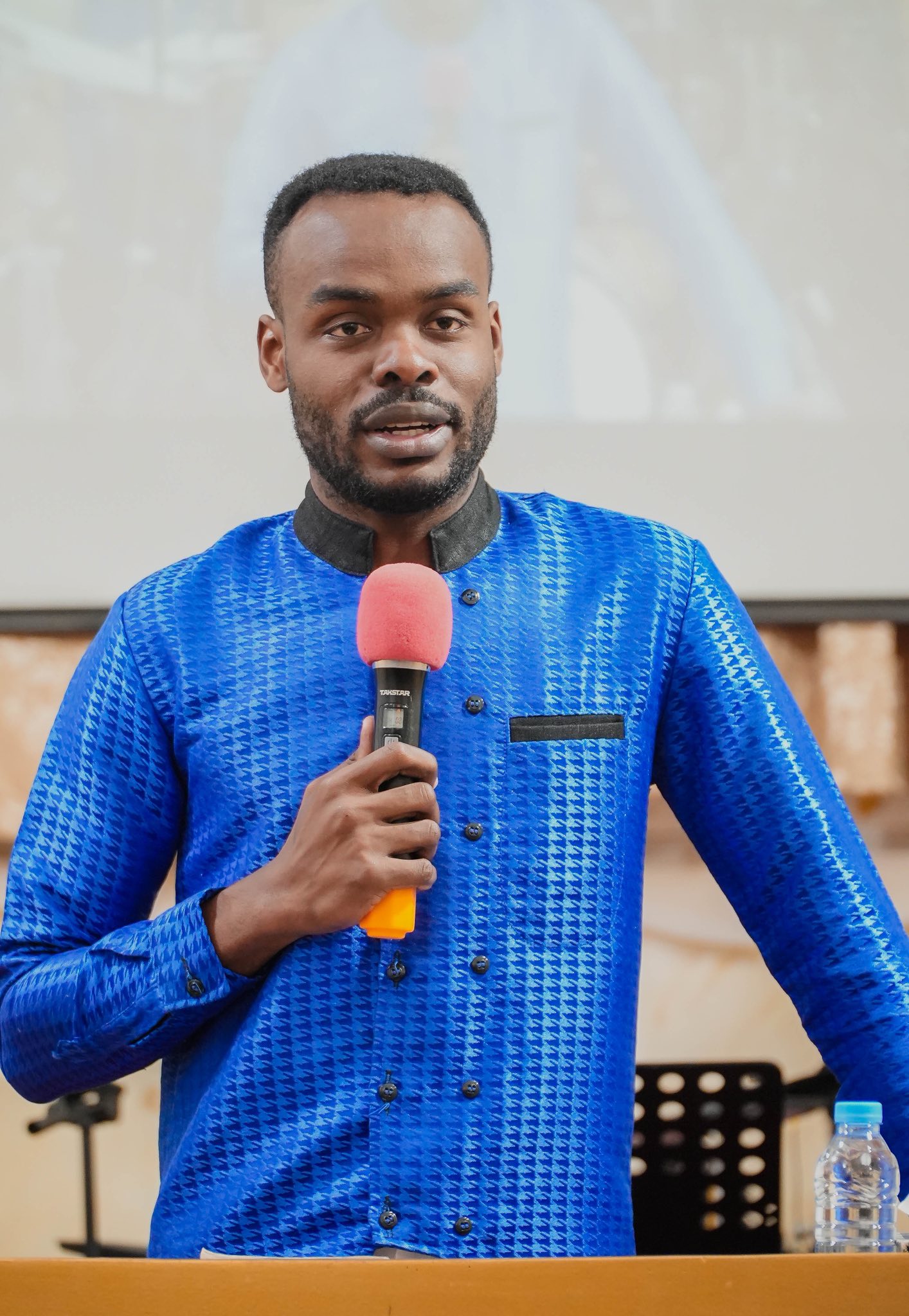 Samuel Kobina Gyasi speaking on stage in traditional attire