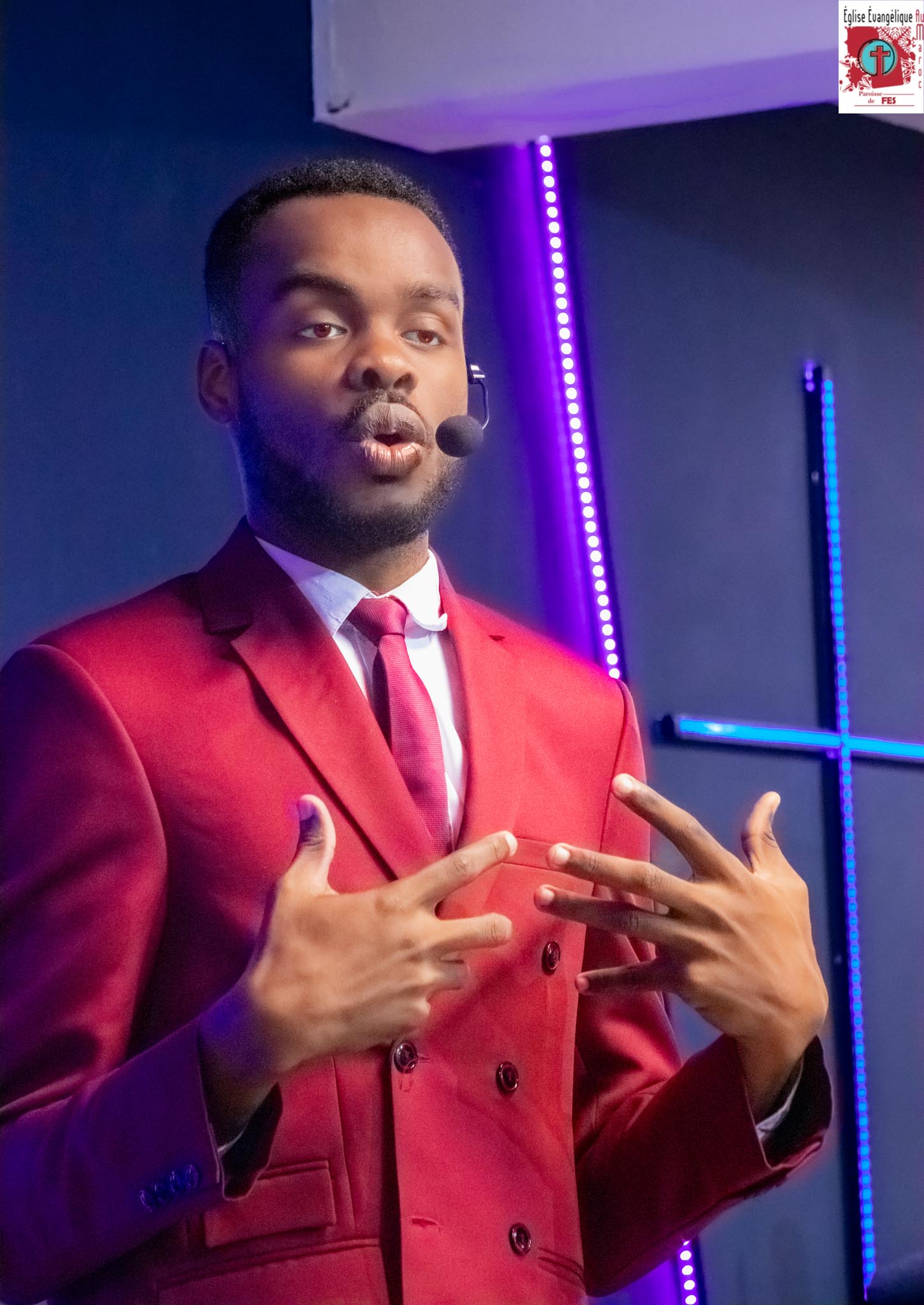 Samuel Kobina Gyasi speaking on stage under coloured lighting